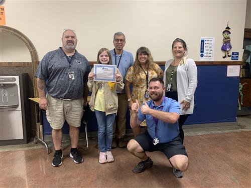 Charlie Coy, Wilson's Stairclimber for the month of October, poses with her certificate with school staff.